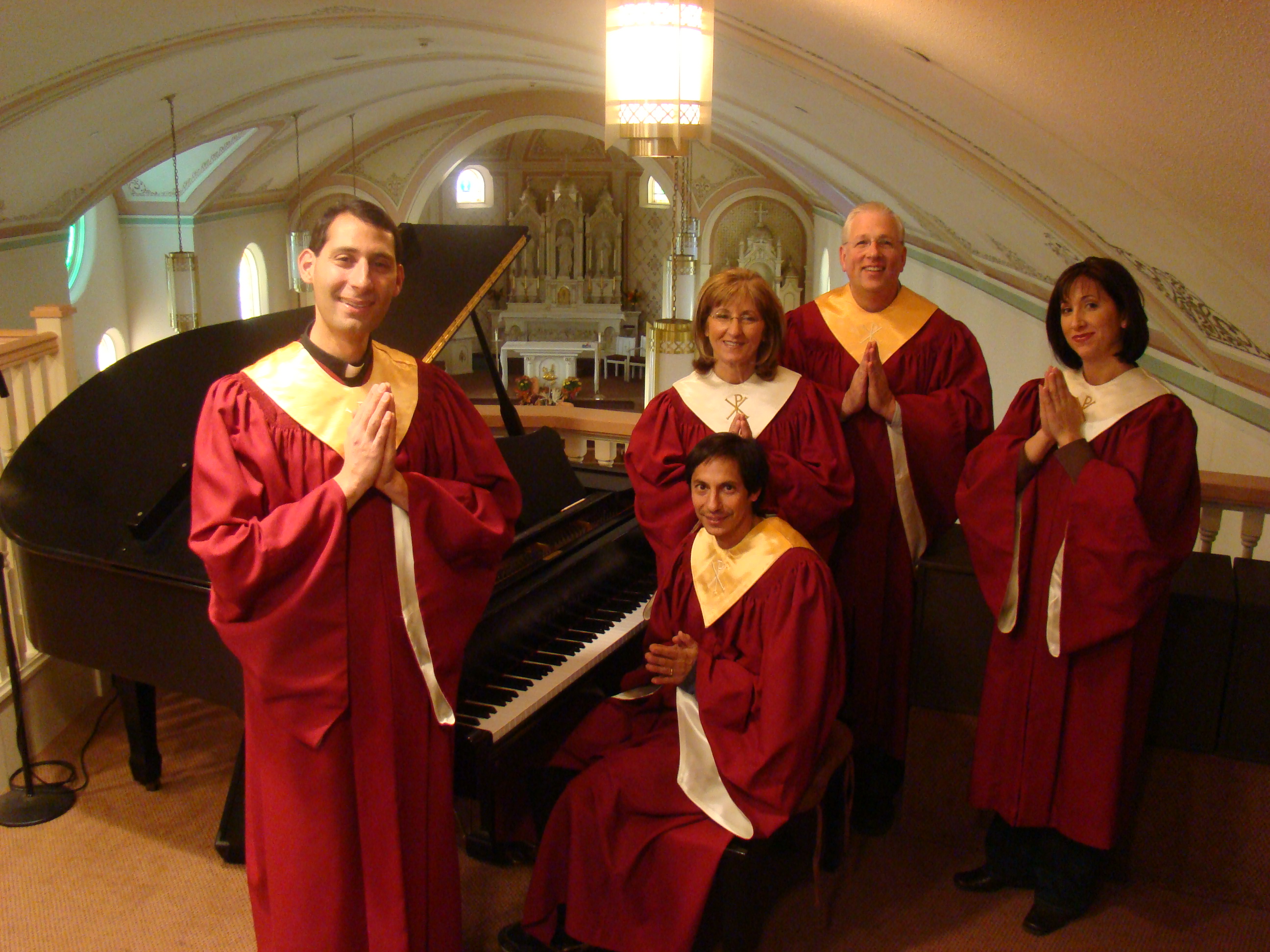 The Holy Smoke Choir beside a grand piano: Fr. Mallick, Gregory Onofrio, Susanne Houston, Gregory Houston, and Christina Houston Doerr